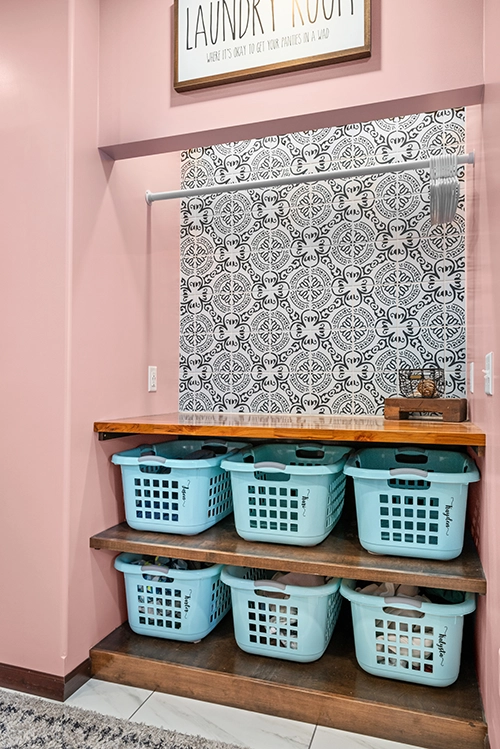 laundry room wall with designed basket shelves, patterned wall, and hanging area